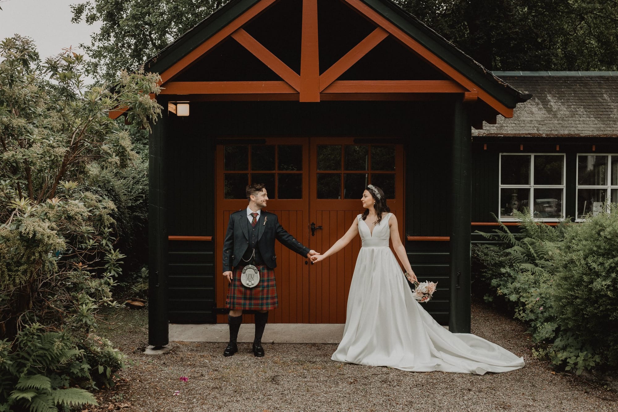 Highland dress outside a woodland cabin